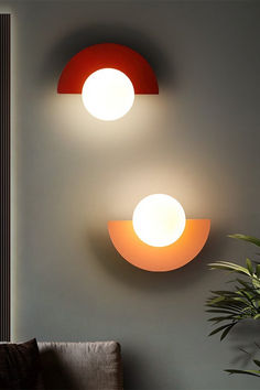 two circular lights are mounted on the wall above a couch in a modern living room