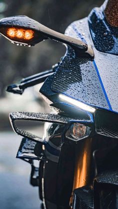 a close up of the headlight and tail light on a motorbike in the rain