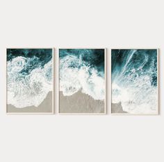 three framed art prints depicting waves crashing on the beach in front of a white wall