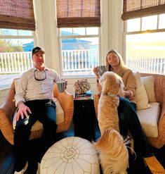 a man and woman sitting in chairs with a dog