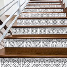 the stairs are decorated with decorative wallpaper and wooden handrails, along with white railing