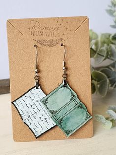 a pair of green and white earrings sitting on top of a card