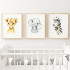 three pictures of animals hanging on the wall next to a baby's crib