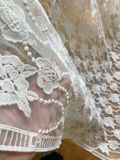 This is a white net, white fabric embroidered with intricate floral motifs from one corner to another. The embroidery is done very neatly so that this can also be used from the backside. There is an embroidered ladder motif on both long edges.  This would make a gorgeous chuppah canopy as it looks like a canopy made from flowers. The embroidery on the net fabric shows on the reverse and front sides.  MATERIAL = soft net, but intricate embroidery adds texture and weight to the fabric.  USAGE = We White Embroidered Fabric With Lace Trim, White Embroidered Fitted Fabric With Lace Trim, Fitted White Embroidered Fabric With Lace Trim, Fitted White Tulle Fabric With Lace Trim, Spring White Embroidered Fabric With Lace Work, Spring White Embroidered Lace Fabric, Summer White Embroidered Lace Fabric, White Embroidered Lace Fabric For Spring, White Embroidered Lace Fabric For Summer