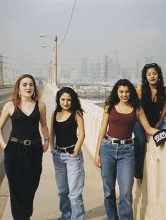 four women standing on the side of a road