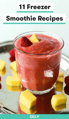 a glass filled with fruit and cheese on top of a metal tray next to sliced strawberries