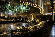 a long table is set up with candles and greenery for an elegant wedding reception