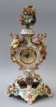 an ornate clock with cherubs and flowers on it's face is shown