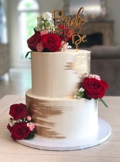 a wedding cake with red roses on top