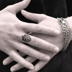 two people with tattoos on their hands holding each other's fingers and wearing matching rings