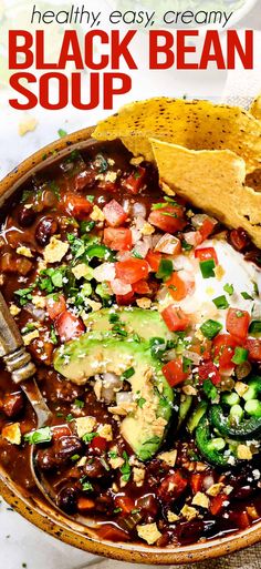 a bowl filled with black bean soup and tortilla chips