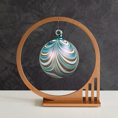 a glass ornament hanging from a wooden stand