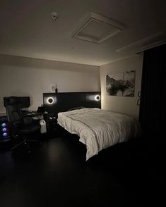 a bed sitting in a bedroom next to a night stand with two lights on it