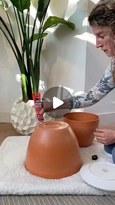 a woman is sitting on the floor making pottery