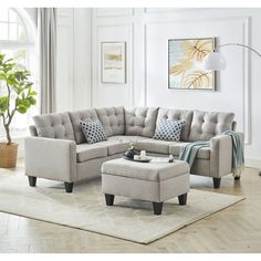 a living room scene with focus on the sectional sofa and footstool in the center