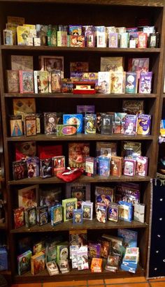 a book shelf filled with lots of books on top of wooden shelves in a room