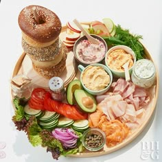 an assortment of food is arranged on a platter with bread, vegetables and dips