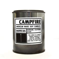 a black candle that is on a white surface and has a label reading leather american made soy candles shoppe b15, suburban california