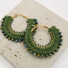 Step into timeless elegance with our Belen Woven Beaded earrings! These hoops are the epitome of chic sophistication, offering a beautiful way to accentuate any outfit. Handcrafted with care by Colombian artisans, they feature bronze hardware plated in gold, adorned with vibrant Czech Mostacilla beads and Murano glass. Available in red, white, and black, these earrings add a touch of color and flair to your ensemble, making them the perfect accessory for any occasion Specifications: Material: Br Elegant Handmade Festive Hoop Earrings, Handmade Green Hoop Earrings For Party, Handmade Hoop Earrings For Festive Occasions, Elegant Green Beaded Hoop Earrings, Bohemian Hoop Earrings With Gold Beads As Gift, Bohemian Gold Beads Hoop Earrings For Gift, Bohemian Gold Beaded Hoop Earrings As Gift, Bohemian Gold Beaded Hoop Earrings For Gift, Bohemian Small Hoop Earrings With Gold Beads