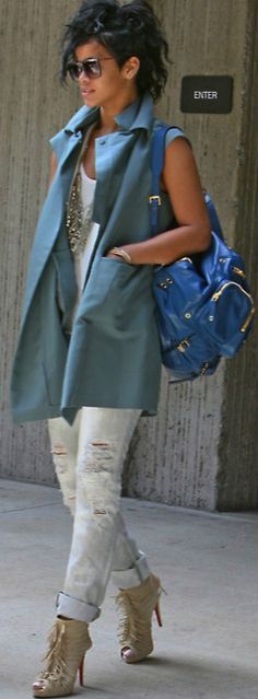 a woman walking down the street carrying a blue purse