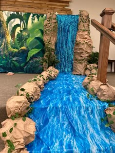 a fake waterfall is in the middle of a room with blue water flowing down it