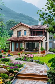 a house that is in the middle of some plants and flowers on the side of it