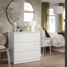 a white dresser sitting in front of a mirror on top of a wooden floor next to a chair