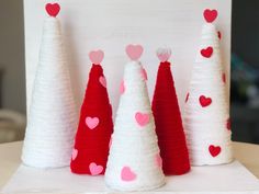 three white and red christmas trees with hearts on them, sitting next to each other