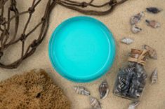 an assortment of sea shells and other items on the sand, including a blue frisbee