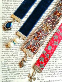 three pieces of jewelry sitting on top of an open book