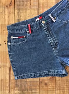 "High waisted 90's denim shorts. Made by Tommy Hilfiger in medium/dark blue denim wash with classic Tommy Hilfiger logos. Shorts are in great clean condition. Perfectly worn in with light naturally distressed character. Logos bright and crisp in color. Measurements (taken zipped or buttoned up and laid comfortably flat) inches x 2 for total circumference (inches) Tag Size 11 Tommy Hilfiger 100% cotton ~ Measure Rise First ~ Waist 30\" Hips 41\"/42\" Length 12\" Inseam 2\" Rise 11\" Bottom leg ci 90s Denim Blue Jean Shorts, 90s Style Denim Blue Jean Shorts, 90s-style Denim Blue Jean Shorts, 90s Denim Jean Shorts, 90s Style Denim Jean Shorts, 90s Style Denim Blue Shorts, 90s Style Medium Wash High-waisted Jean Shorts, 90s High Rise Dark Wash Jean Shorts, 90s Style High Rise Dark Wash Jean Shorts