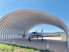 an airplane is parked under a large metal structure