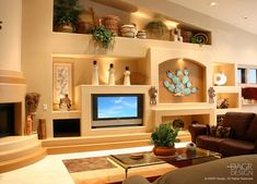 a living room filled with furniture and a flat screen tv sitting on top of a wall