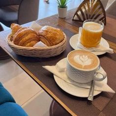 two cups of coffee and croissants on a table