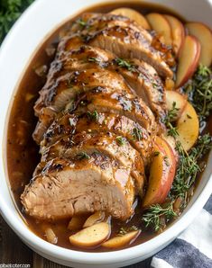 pork roast with apples and gravy in a white bowl