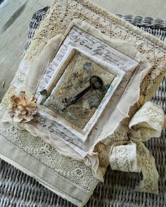 an old clock is sitting on top of some laces and fabric, with flowers in the middle