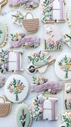 decorated cookies are arranged on a table with the letters i - d and flowers in them