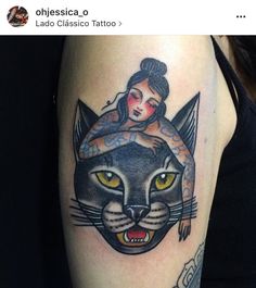 a woman with a tattoo on her arm is holding a black and grey cat's head