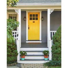 a yellow front door on a gray house