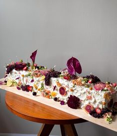 an elaborately decorated cake sitting on top of a wooden table next to a wall