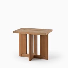 a small wooden table sitting on top of a white surface with no one around it