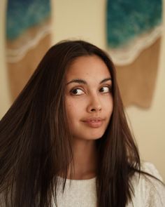 a woman with long brown hair looking at the camera