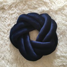 a close up of a blue knot on a white rug