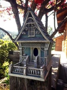 a bird house sitting on top of a tree stump