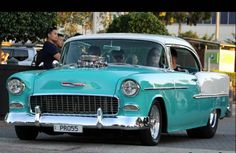 an old blue car is parked on the street