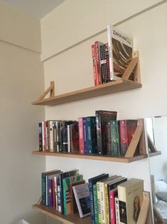 two wooden shelves filled with books on top of each other