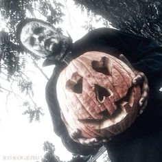 a man holding a carved pumpkin in his hands