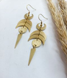 New Witchy Statement Celestial earrings 🌙 . Made of raw brass parts. No nickel No lead . 📍On this design two options are available: 》drop shaped part on the bottom 》 triangle on the bottom . The item will arrive to you wrapped as a gift in a little paper gift bag. . If you have any questions please contact me, I usually respond quite fast ♡ . 》Please before ordering read my shop's announcement and check carefully the estimated delivery time Etsy gives you. I am only responsible for shipping yo Moon-shaped Brass Earrings For Festival, Festival Moon-shaped Brass Earrings, Brass Moon Shaped Festival Earrings, Bohemian Brass Earrings With Moon Phase, Bohemian Brass Moon Phase Earrings, Festival Moon Phase Brass Earrings, Brass Moon Charm Earrings For Festival, Bohemian Brass Earrings With Moon Phase Detail, Moon Phase Brass Earrings For Festival