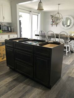 a kitchen with white chairs and black cabinets