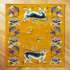 a yellow rug with blue and white animals on it